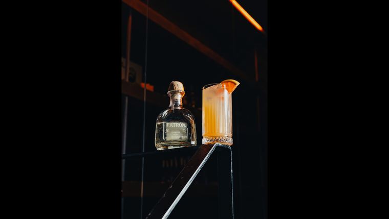 Cocktail en fles achter de bar bij Soho.